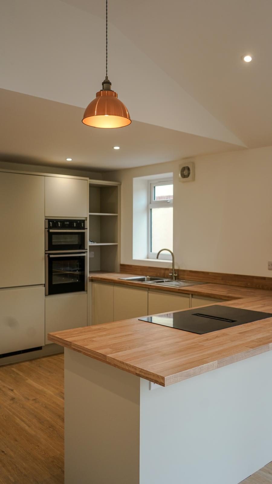 Finished open-plan kitchen extension with island and pendant lights